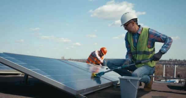 Güneş panellerini temizleyen ve koruyan teknisyenler — Stok video