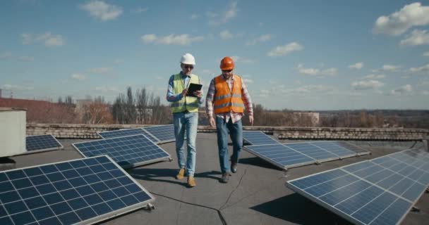 Engenheiro e técnico discutindo entre painéis solares — Vídeo de Stock