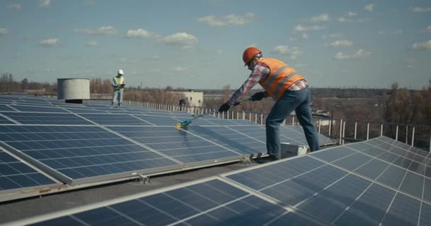 Técnico de limpieza de paneles solares en techo plano — Vídeos de Stock