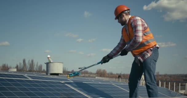 Técnico de limpieza de paneles solares en techo plano — Vídeo de stock