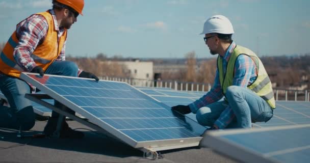 Tekniker som installerar solpaneler på metallstativ — Stockvideo