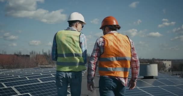 Inženýr a technik diskutující mezi solárními panely — Stock video