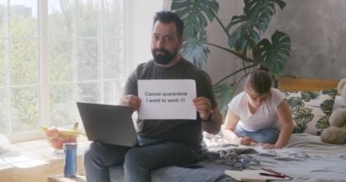 Kameraya karantina karşıtı mesaj gösteren bir adam
