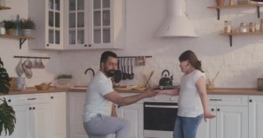 Baba ve kızı mutfakta dans ediyor.