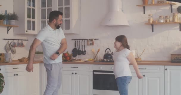 Отец и дочь танцуют на кухне — стоковое видео