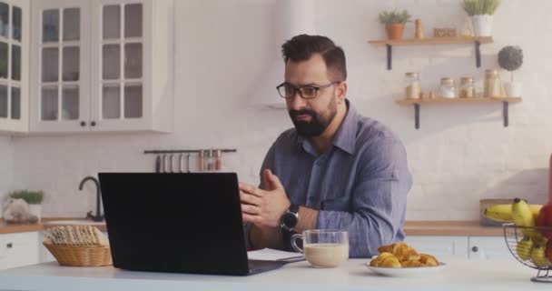 Homem fazendo uma chamada de vídeo na cozinha — Vídeo de Stock