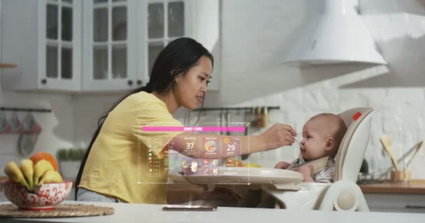 Madre alimentando al bebé en cocina — Vídeo de stock