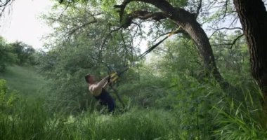 Spor askıları kullanan atletik bir adam