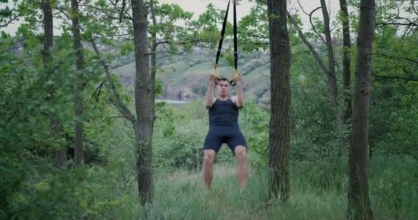 Athletic man using sport slings — Stock Video