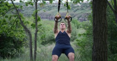 Spor askıları kullanan atletik bir adam