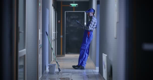 Janitor usando um smartphone — Vídeo de Stock