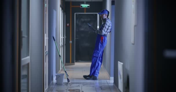 Janitor using a smartphone — Stock Video