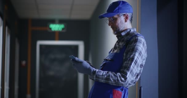 Janitor usando um smartphone — Vídeo de Stock