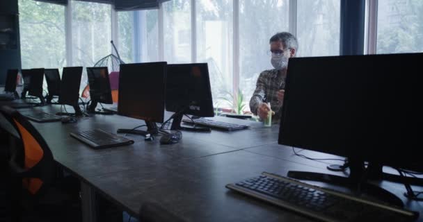 Hombre desinfectando manos en el lugar de trabajo — Vídeos de Stock