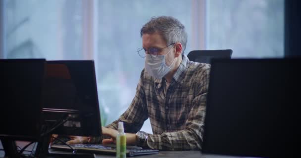 Mascarilla usando hombre trabajando en la oficina — Vídeos de Stock