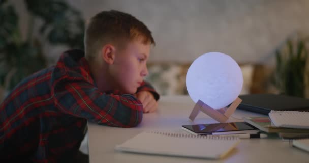 Pojke ändrar färg på bordslampa — Stockvideo