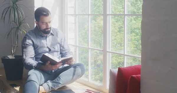 Muž čte Bibli doma — Stock fotografie