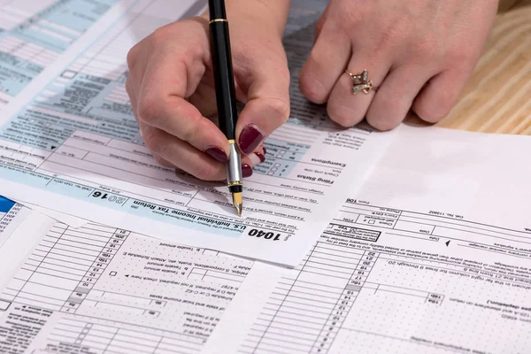 a woman fills in the tax form 1040