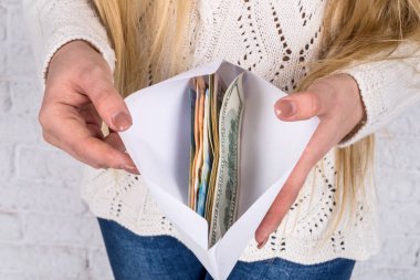 kadının zarf ile dolar ve euro banknot eller.
