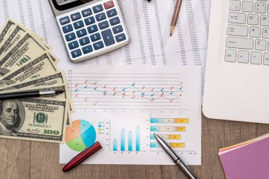 Dolarlarına graph grafiği ve dizüstü bilgisayar, kalem ve hesap makinesi ile bir tabloda