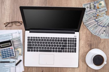 vergi formu, laptop, kahve ve Doları üstünde okul sırası