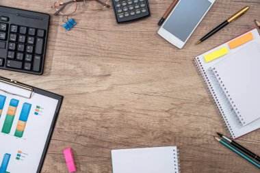Not Defteri, iş grafik kağıt, klavye laptop, hesap makinesi, cep telefonu, kalem, ahşap masa üzerinde