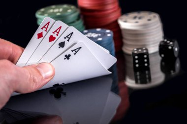 Poker fişleri ve siyahta izole oyun kartı