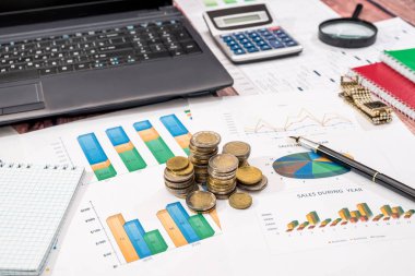 Çizelgeler ve grafikler dizüstü bilgisayar ile verilere ve not etmek üstünde okul sırası, Finans Muhasebe.