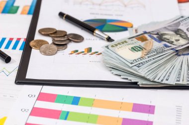 para, sikke üzerinde hisse senedi grafiği, hesap makinesi ve kalem.