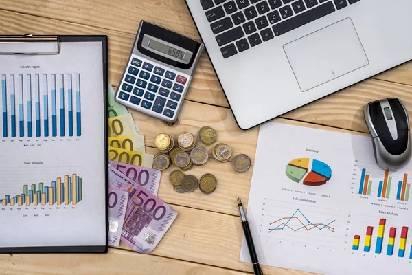 Business chart with euro, laptop and calculator on desk