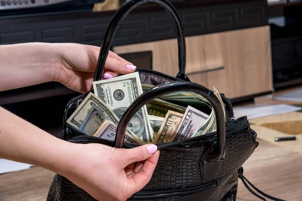 girl extract dollars from the full-packed bags of money.