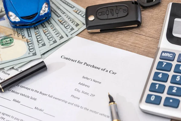 documant, dollar, pen, calculator and toy car with keys.