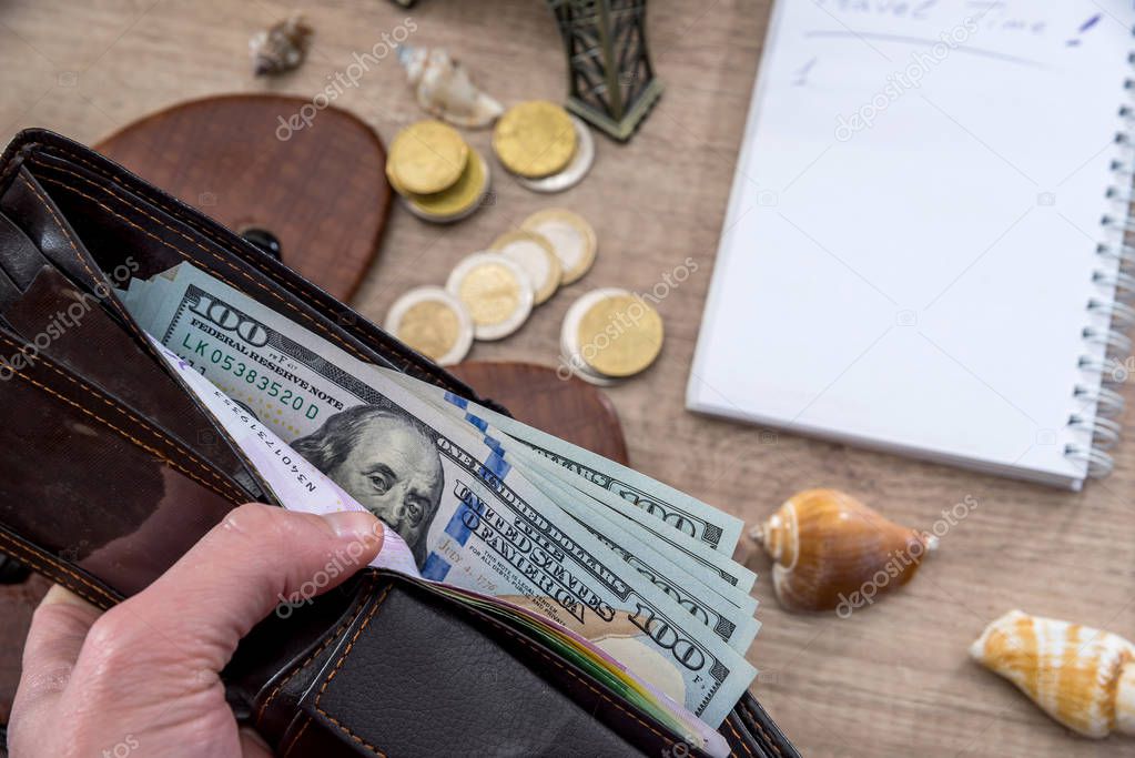 travel concept - old camera, empty notebook with pencil, dollar bills, compass, seashell, phone.