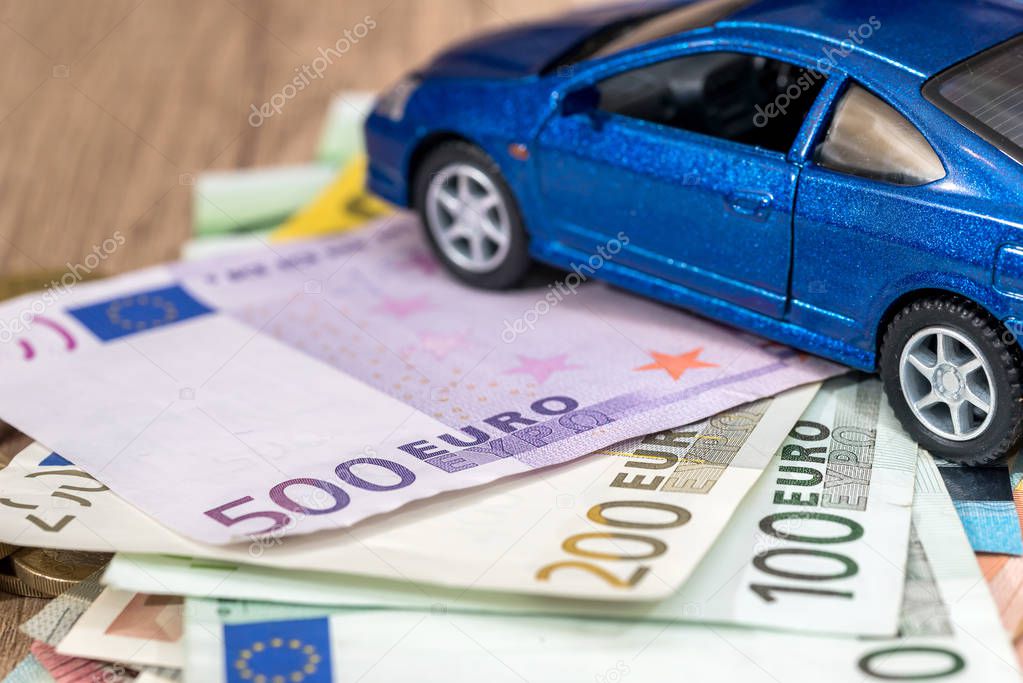 Car and money concept - toy automobile with euro money.