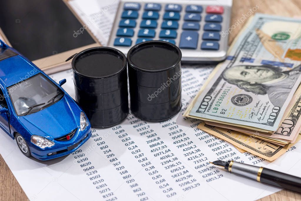 oil price, pen, blue toy car, cash on desk.