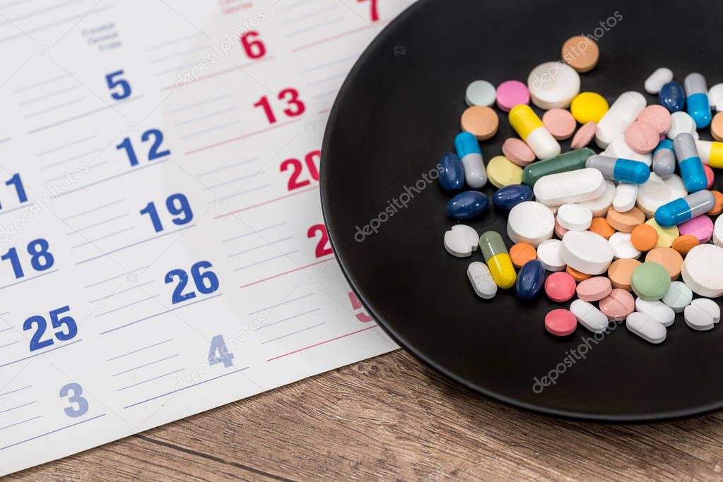 Colorful pills on plate on a calendar medication.