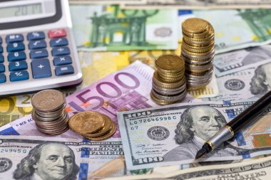 Euro ve dolar faturaları kalem, sikke ve hesap makinesi ile.