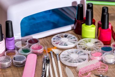 Lamba Lehçe, tırnak cilası ve Aksesuar ahşap arka plan üzerinde