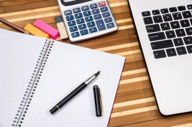 Office tablo workspace dizüstü bilgisayar, not defteri, kalem, telefon ve hesap makinesi ile