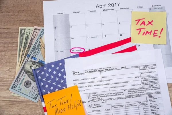 text tax time on tax form with flan, money and calculator.