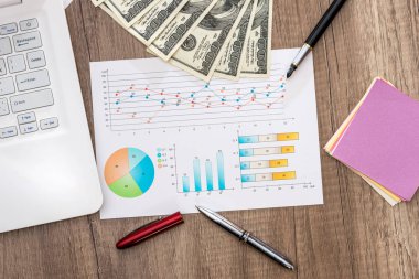 Dolarlarına graph grafiği ve dizüstü bilgisayar, kalem ve hesap makinesi ile bir tabloda