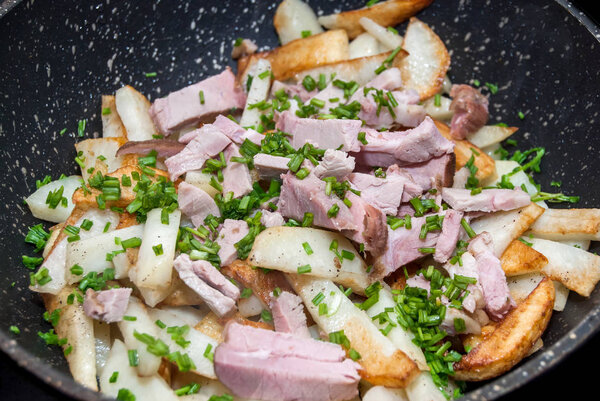 Fried potatoes with ham and green onions
