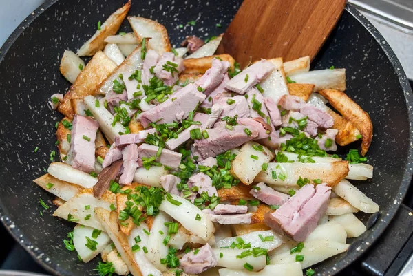 Fried potatoes with ham and green onions