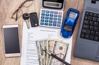 dizüstü bilgisayar, arabayla ilgili satınalma belgesi, Doları, hesap makinesi, kalem ve oyuncak araba