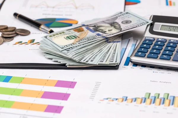 para, sikke üzerinde hisse senedi grafiği, hesap makinesi ve kalem.