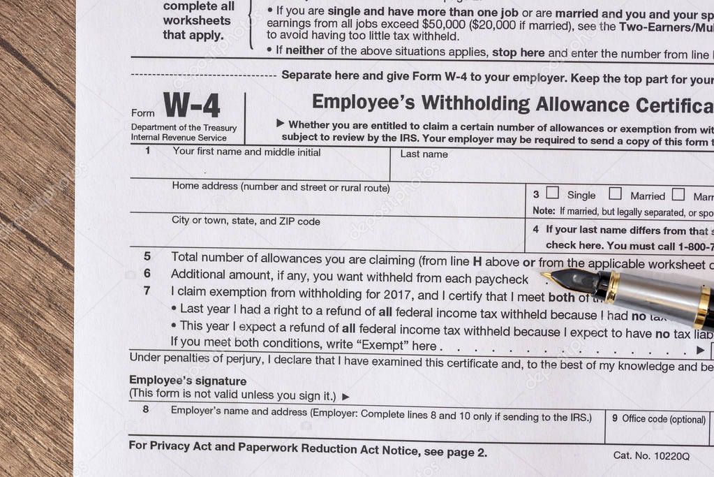 w 4 tax form with pen on desk.