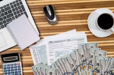 kahve, dizüstü bilgisayar, kalem ve hesap makinesi ve Doları vergi formu