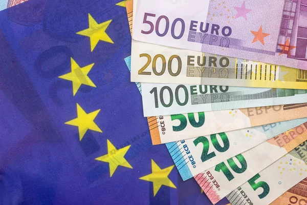 Γραμμάτια Ευρώ Στο Φόντο Ευρωπαϊκή Σημαία — Φωτογραφία Αρχείου