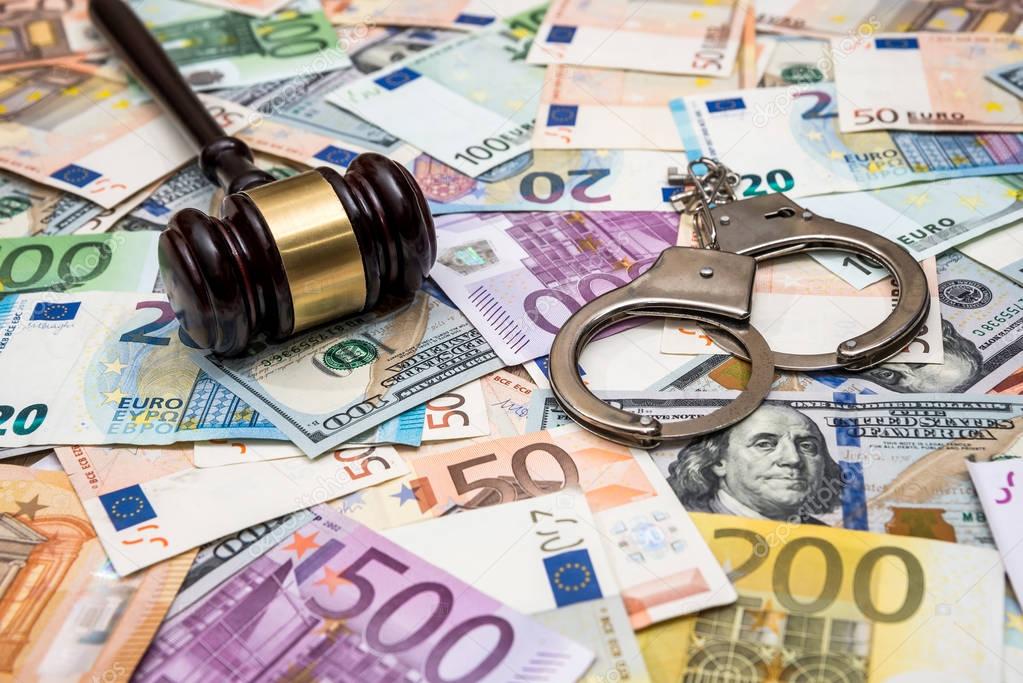 crime concept - handcuffs, gavel dollar and euro bills