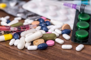 Şırınga ve haplar masanın üstünde.